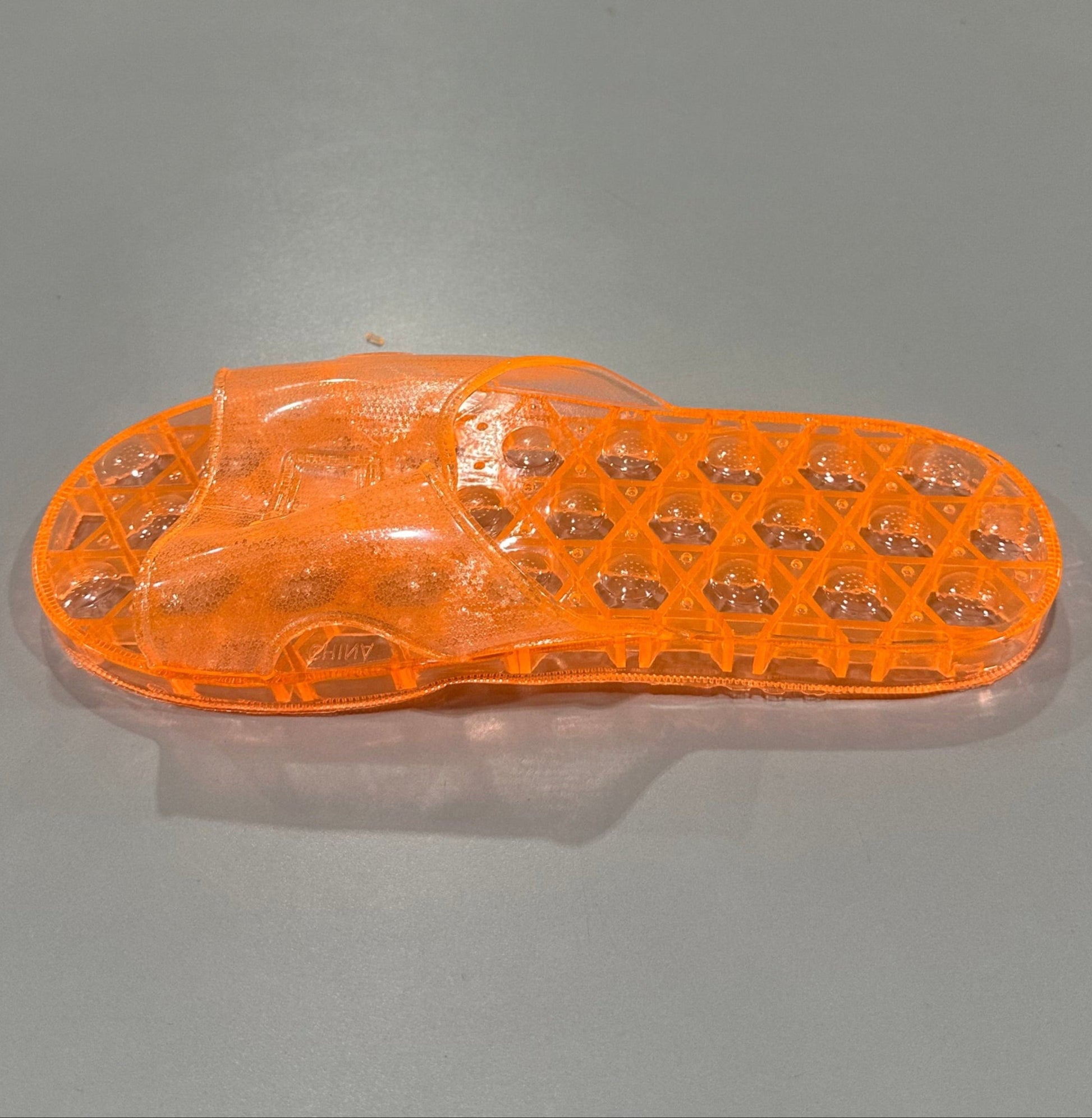 right pair of shower sandal in translucent orange
